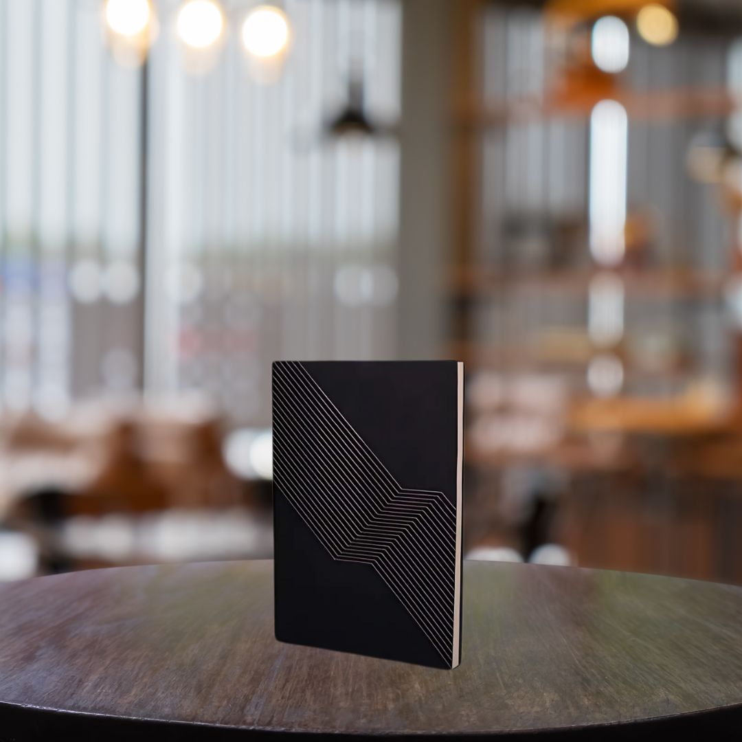 Black A5 undated notebook with embossed cover on table