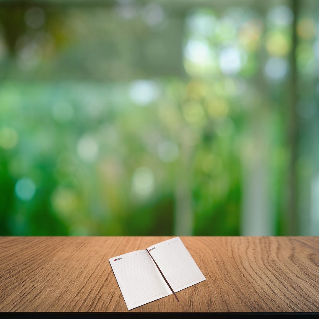 Open notebook showing lined 80 GSM pages with bookmark ribbon