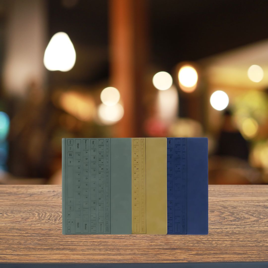 Trio of Castillo Milano keyboard notebooks in gray, brown, and blue