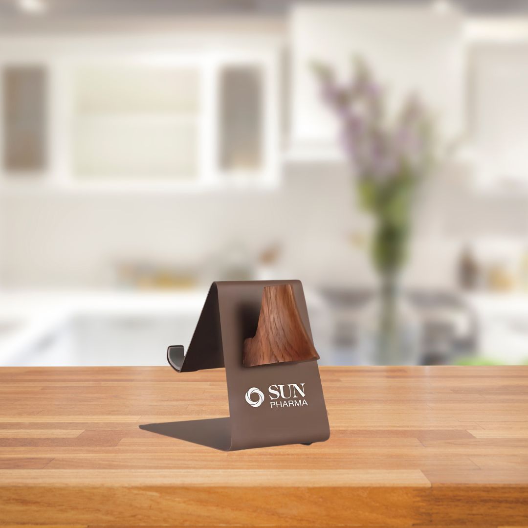 Lifestyle image of metal phone stand holding spectacles on wooden table