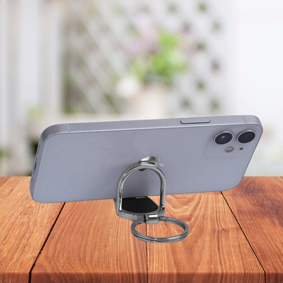 Keychain used as phone stand on wooden desk – lifestyle view