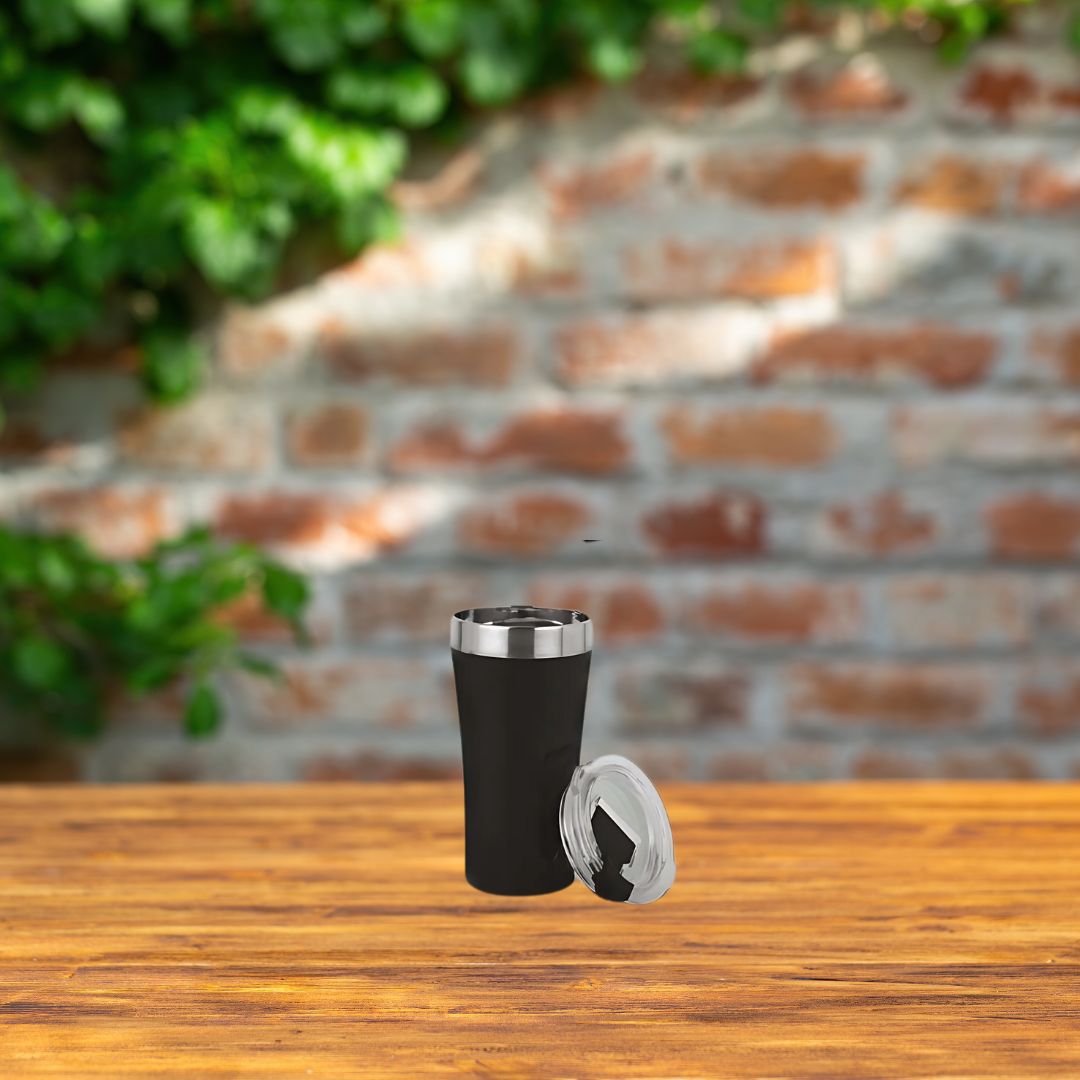 Black stainless steel tall sipper mug with lid on wooden table